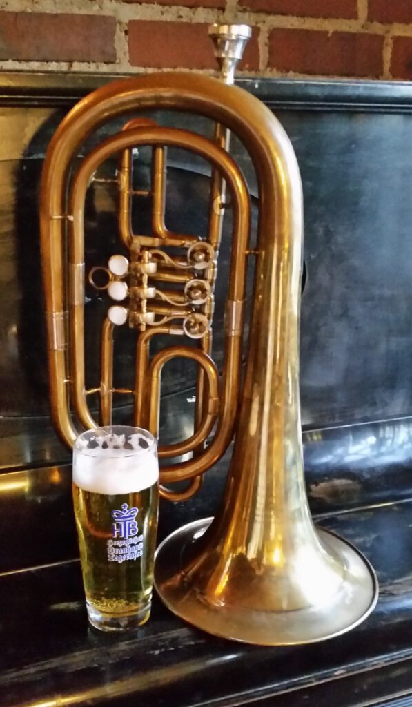 Ein Bassflügelhorn neben einem Glas Weißbier